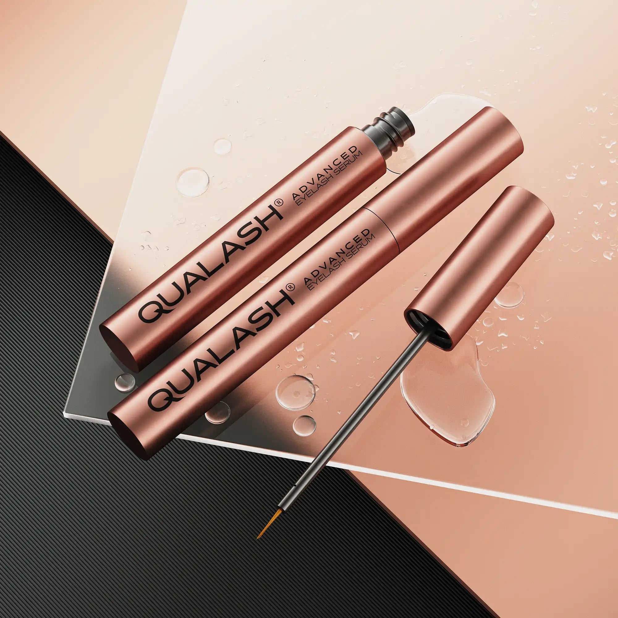 QUALASH Advanced Eyelash Serum – luxury flat lay with rose gold tubes and water droplets